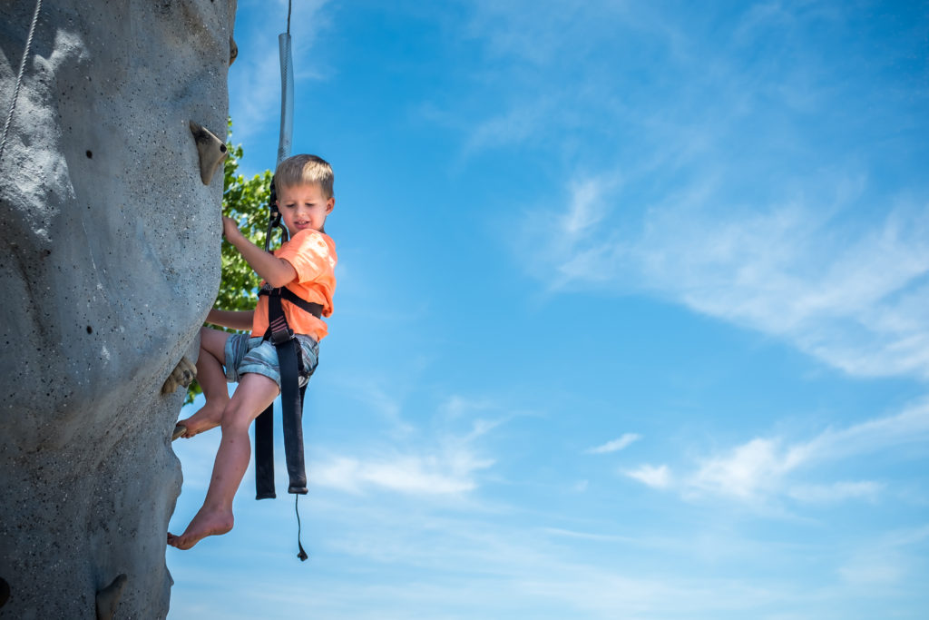 little boy child climbing a rock wall